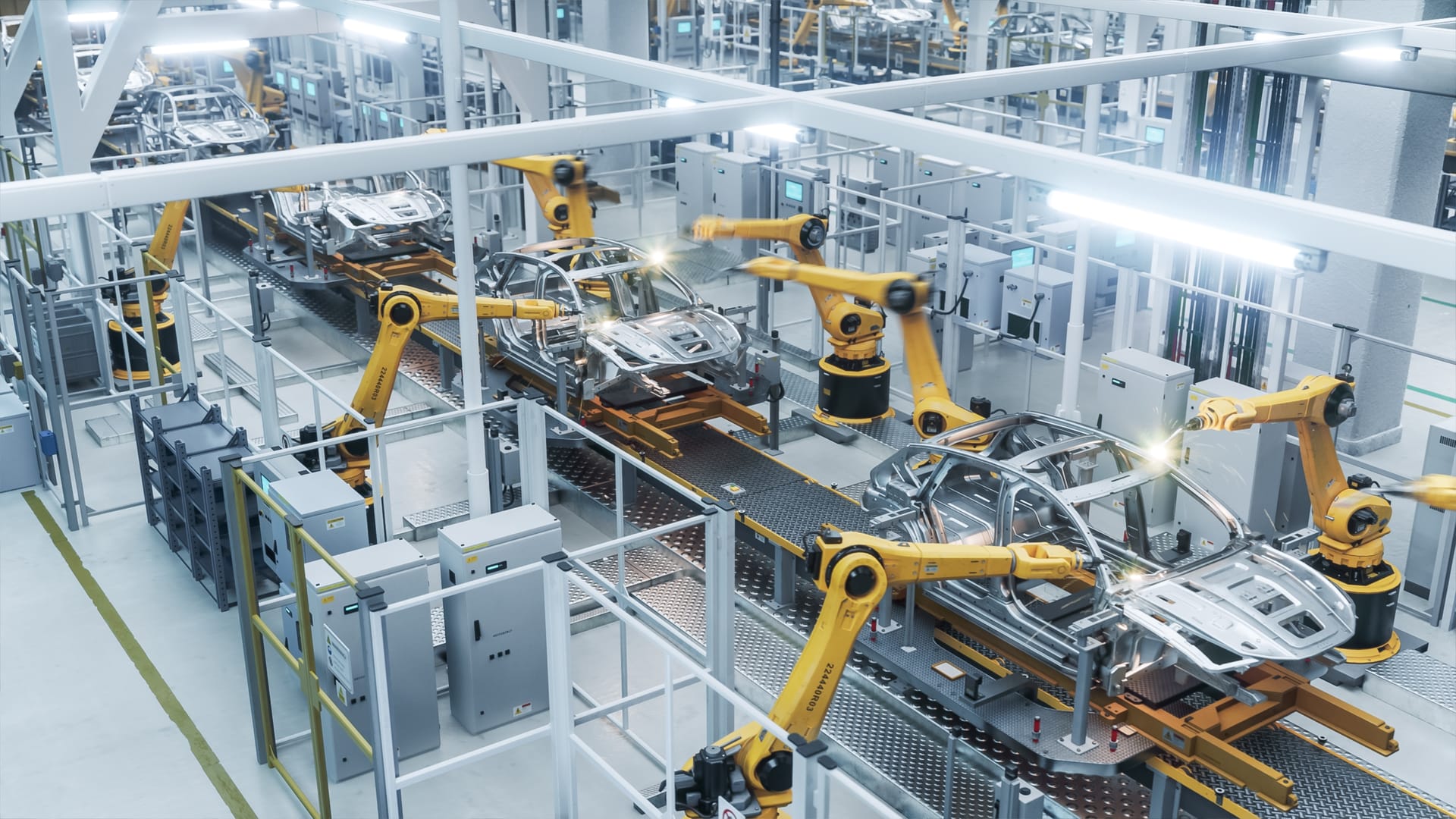 Overhead view of yellow welding robots on a factory line