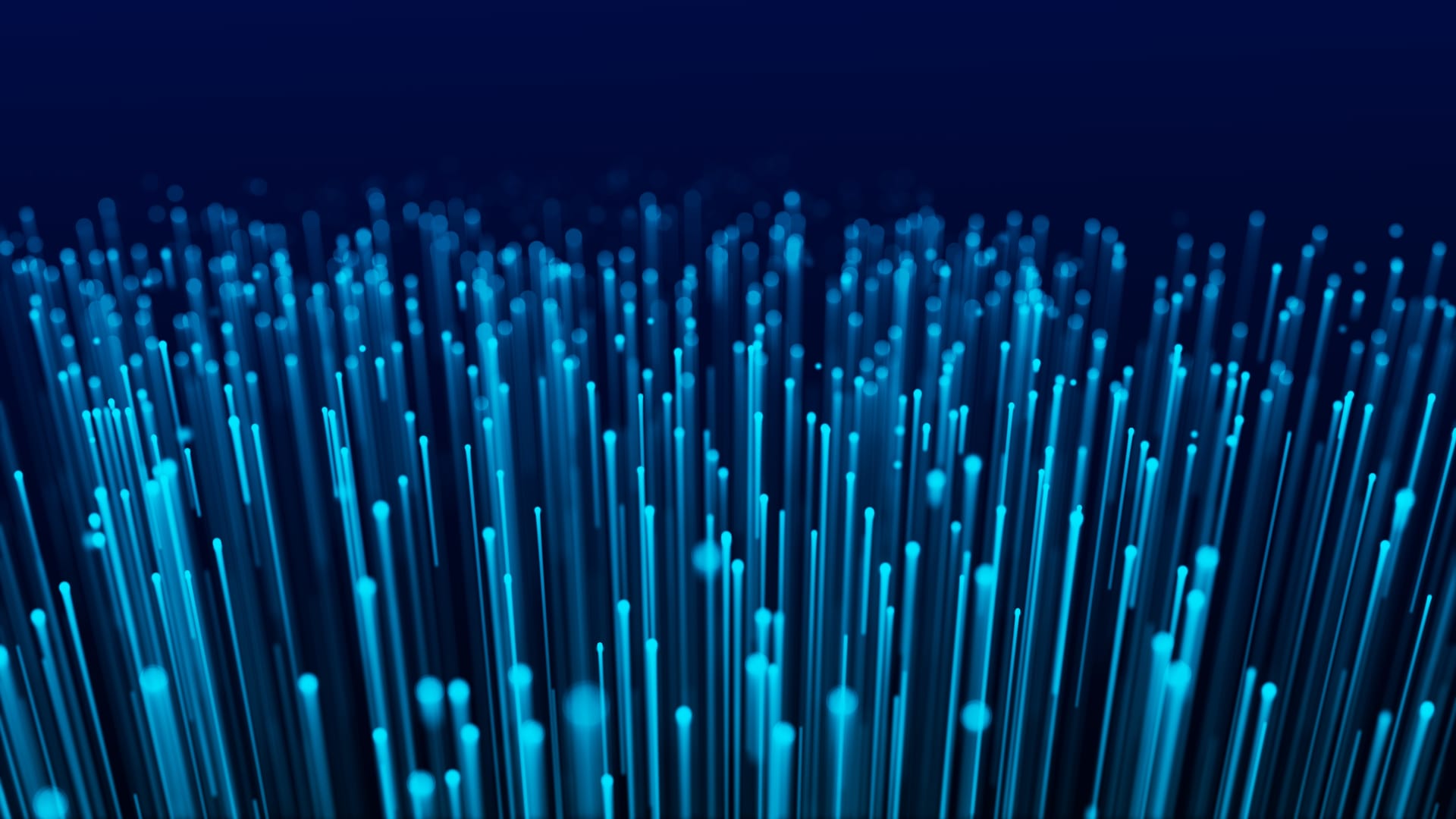 Blue fiber optic strands rising on a dark background
