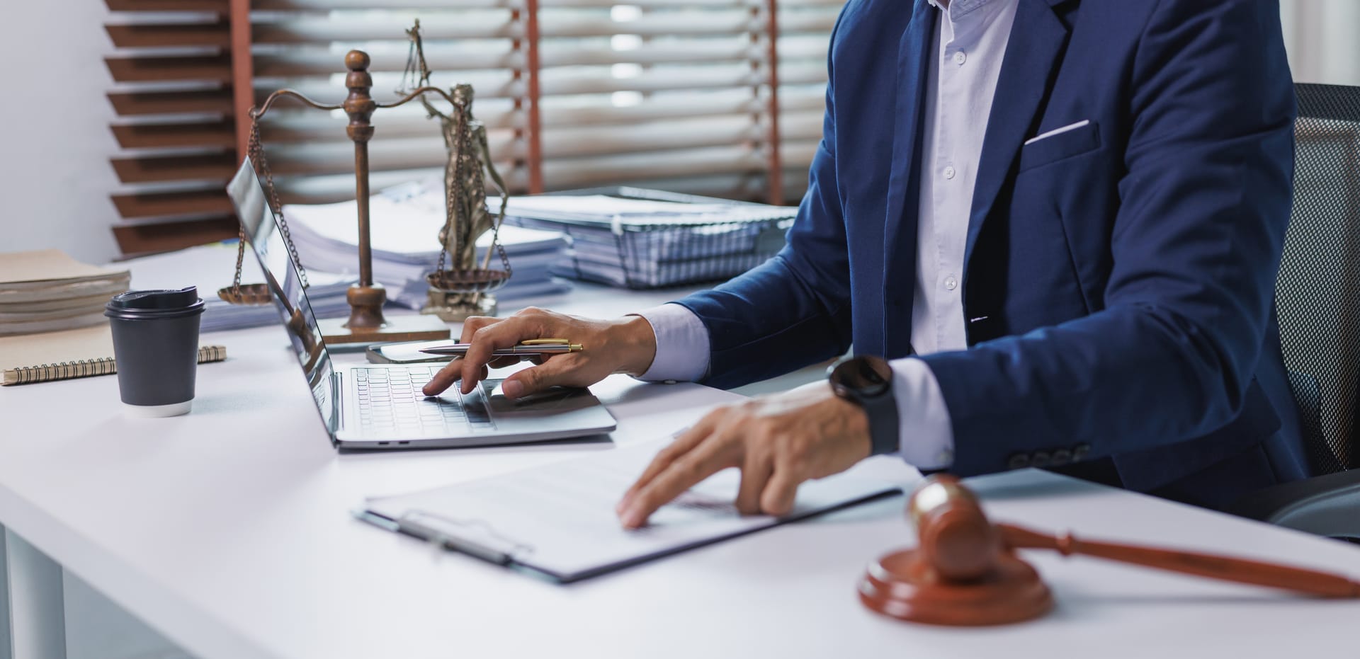 Lawyer reviewing legal documents with a laptop at a desk