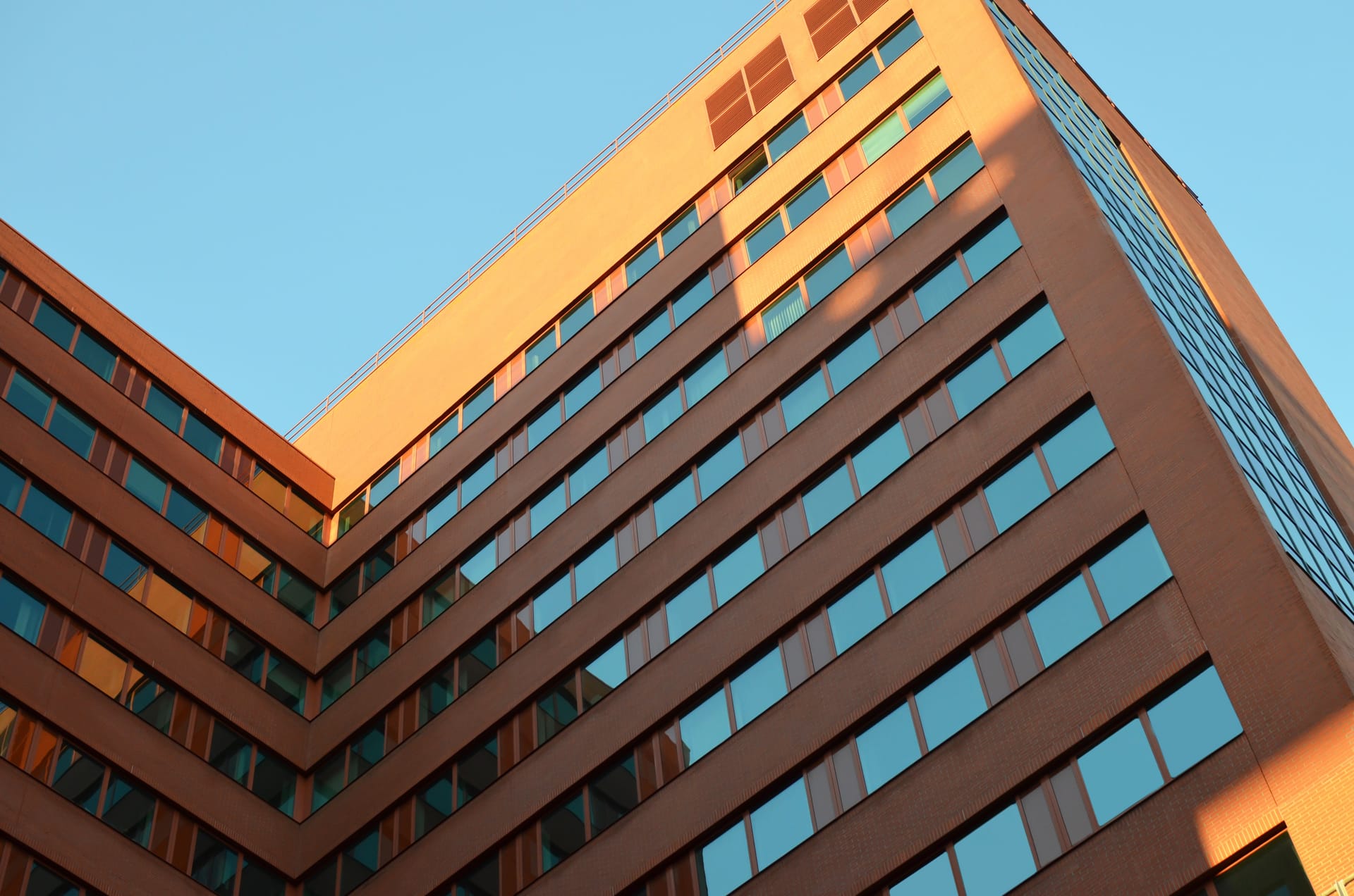 Low angle of a modern office building against a blue sky
