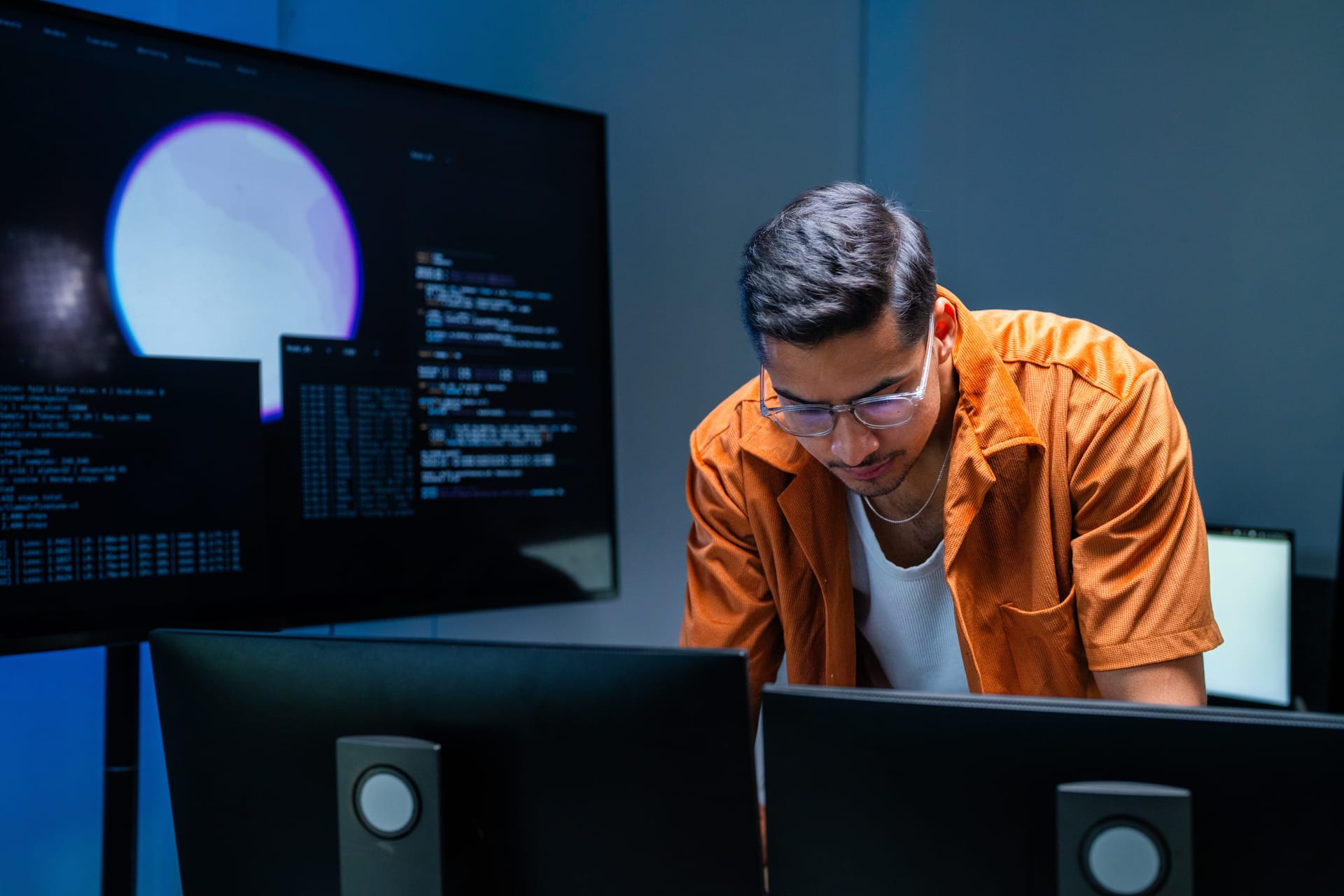 Security analyst studying data on dark monitors