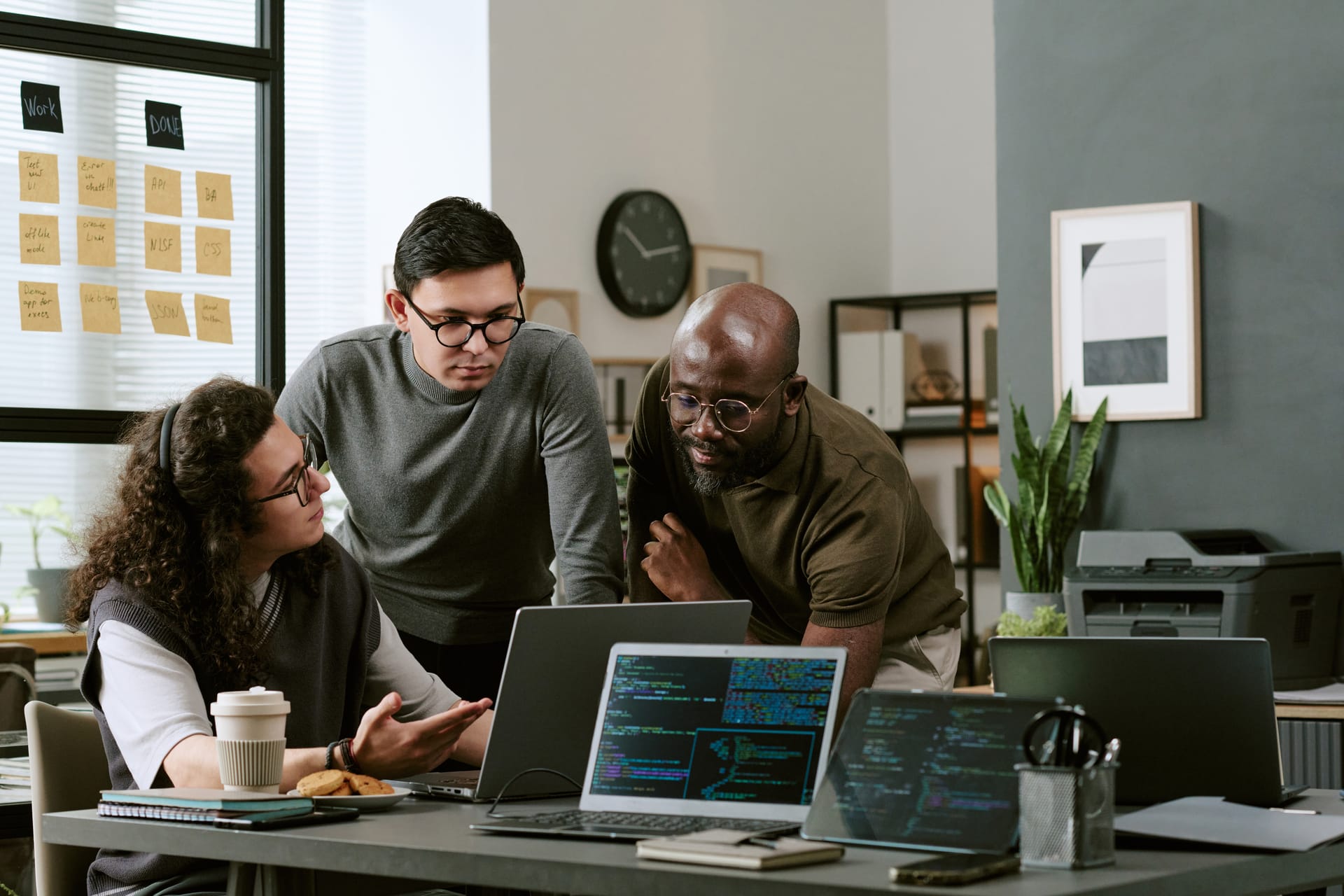 Development team gathered around a laptop reviewing code