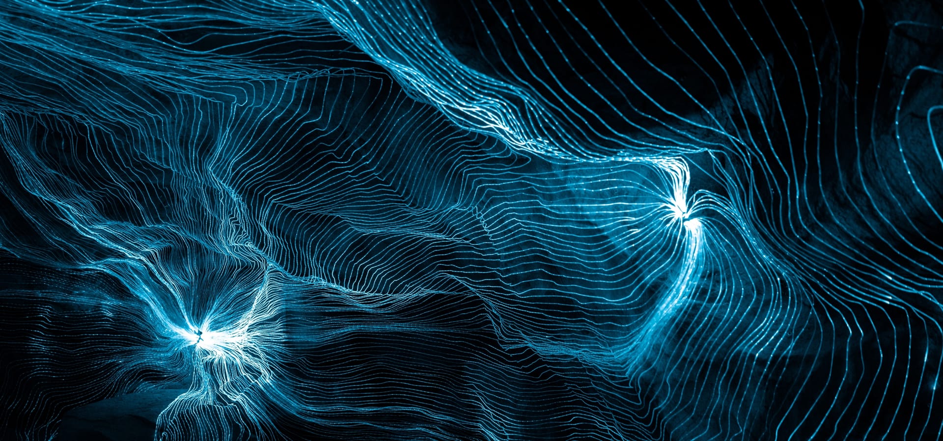 Streams of blue light lines flowing across a dark field